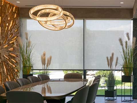 An upscale meeting room with large windows and intricate chandelier